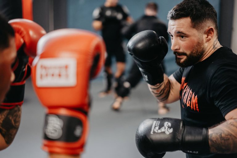 Intensives Sparring beim Boxtraining in der Sportschule Harrycane, fokussierter Athlet mit schwarzen Handschuhen.