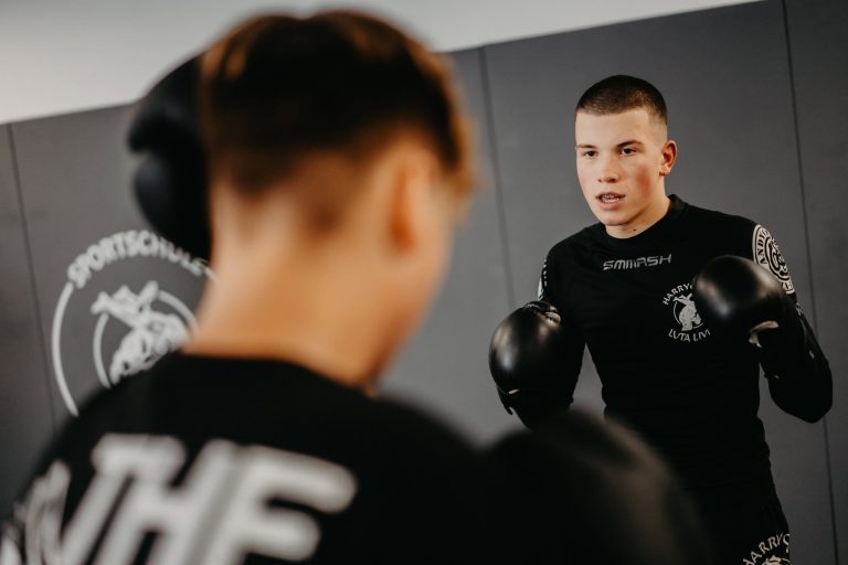 Zwei Jugendliche beim MMA-Training in der Sportschule Harrycane in Herford, konzentriert mit Boxhandschuhen.